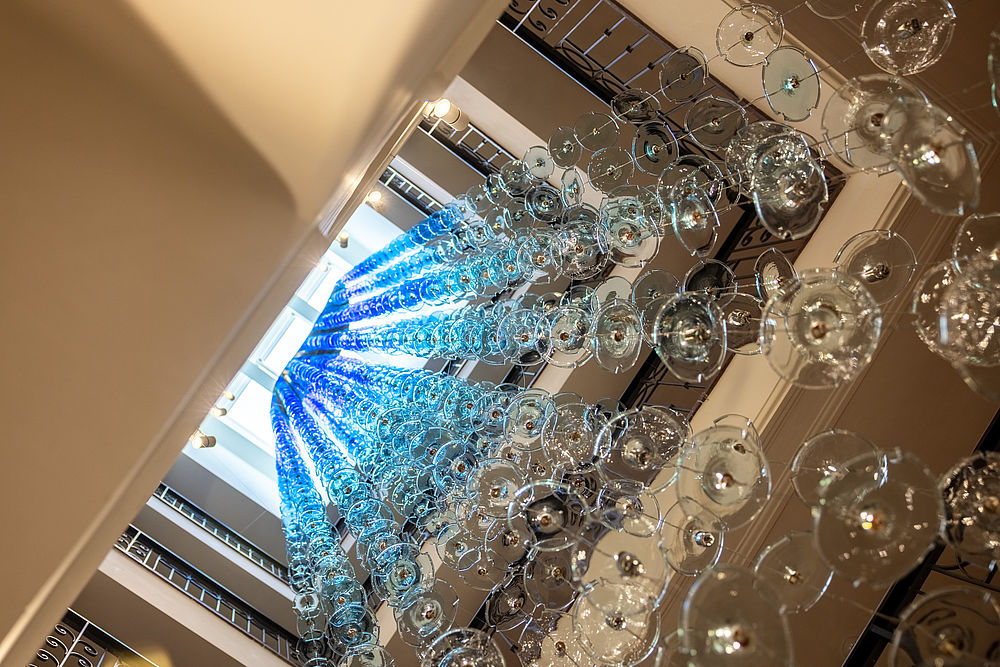 Designerlampe aus blau-weißen Glasscheiben der venezianischen Manufaktur Barovier und Toso im Treppenhaus des Luxushotel Stein