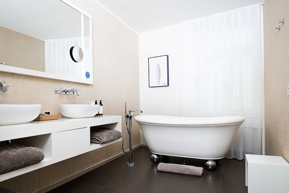 Badezimmer der Suite im Hotel Stein mit freistehender Wanne und weißer Waschtischkonsole mit zwei Becken