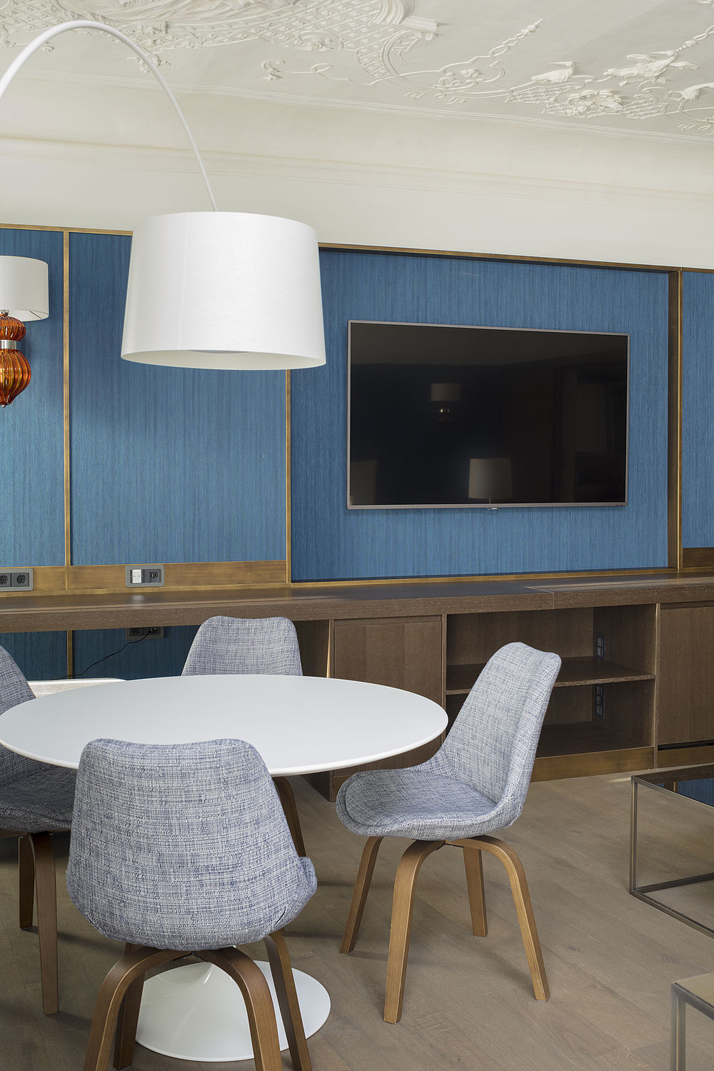 Sitzecke in der Honeymoon-Suite des Designhotel Stein mit hellblauen Polsterstühlen und weißem Tisch und Flachbildschirm